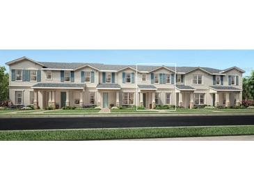 Charming townhome with neutral siding, blue shutters, covered entryway, and inviting landscaping at 1667 Eaglehurst Ln, Apopka, FL 32703