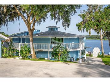 Stunning two-story home with a white railing balcony and a lake view at 36607 E Eldorado Lake Dr, Eustis, FL 32736