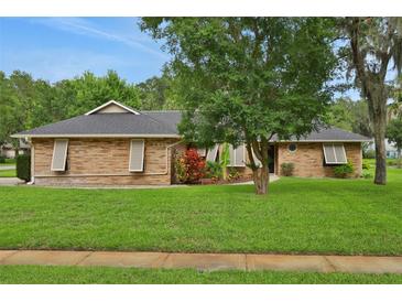 Charming single-story brick home with a well-manicured lawn and mature landscaping at 5929 Hatteras Dr, Port Orange, FL 32127