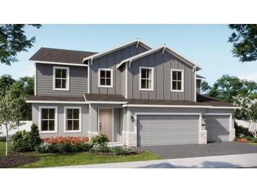 Charming two-story home featuring a two-car garage, gray siding, and beautifully landscaped front yard at 679 Birsdwill Ln, Deland, FL 32720