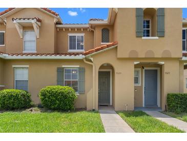 Charming townhome with a terra cotta roof, green shutters, and well-manicured landscaping at 7625 Long Island Dr, Kissimmee, FL 34747