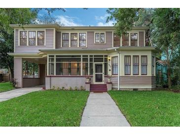 Charming two-story home featuring a screened front porch, classic architectural details, and lush green lawn at 803 E Hardwood St, Orlando, FL 32803