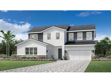 Modern two-story home featuring a two-car garage, paver driveway, and beautiful landscaping at 1508 Stonecliff Dr, Apopka, FL 32703