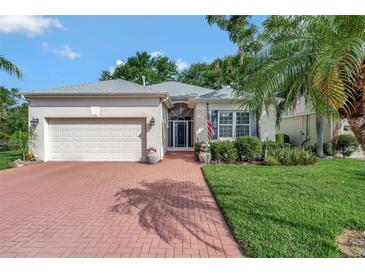 Charming single-story home with a brick driveway, well-manicured lawn, and beautiful landscaping at 2500 Castle Pines St, Clermont, FL 34711