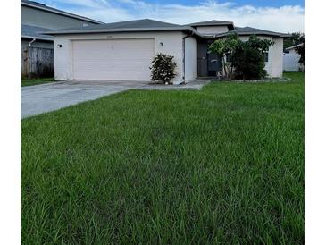 Charming single-story home featuring a well-maintained front yard and a two-car garage at 2765 Montego Bay Blvd, Kissimmee, FL 34746