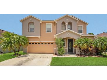 Charming two-story home with a two car garage, lush landscaping, and inviting front entrance at 3009 Park Ridge Ave, Mulberry, FL 33860
