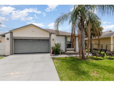 Charming single Gathering home featuring an attached garage, palm tree and landscaped yard at 3280 Pinto Dr, Kissimmee, FL 34746
