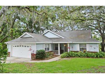 Charming single-story home with attached garage and lush landscaping at 33042 Lake Bend Cir, Leesburg, FL 34788