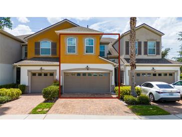 Two-story townhouse featuring an attached garage and well-maintained landscaping at 3508 Brighton Park Cir, Belle Isle, FL 32812