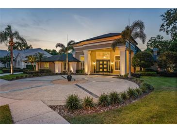 Stunning home featuring a circular driveway and grand entrance with columns and mature landscaping at 4048 Gilder Rose Pl, Winter Park, FL 32792