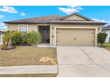 Charming single-story home featuring an attached two-car garage and well-maintained landscaping at 411 Ridges Dr, Dundee, FL 33838