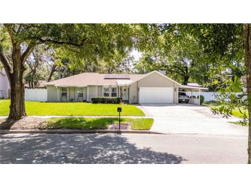 Charming single-story home features a well-manicured lawn, mature trees, and a convenient carport in a desirable neighborhood at 5177 Chesapeake Ave, Orlando, FL 32808