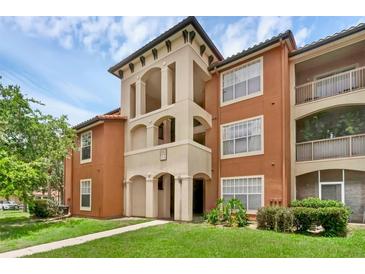 Attractive condo building featuring Mediterranean-style architecture, lush landscaping, and a well-maintained lawn at 5512 Metrowest Blvd # 201, Orlando, FL 32811