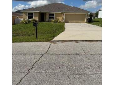 Charming single story home featuring a well-maintained lawn and a two-car garage at 107 Athabasca Dr, Poinciana, FL 34759