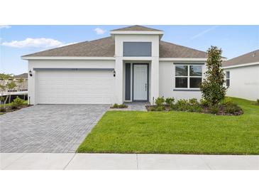 Charming single-Gathering home features a two-car garage, manicured lawn, and neutral-colored exterior at 1568 Gardiner St, Haines City, FL 33844