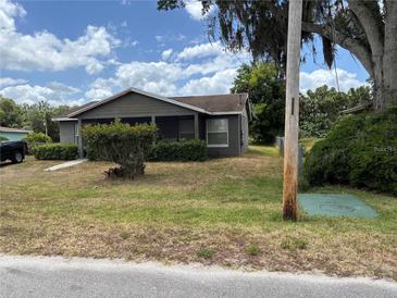 Charming single-story home featuring a cozy screened porch and well-maintained landscaping, enhancing curb appeal at 3411 Hughey St, Sanford, FL 32771