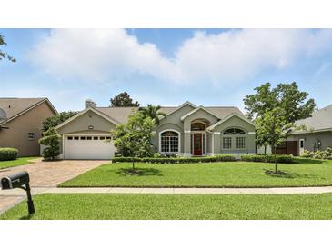 Charming single-story home with a well-manicured lawn and a two-car garage at 3618 Rothbury Dr, Belle Isle, FL 32812