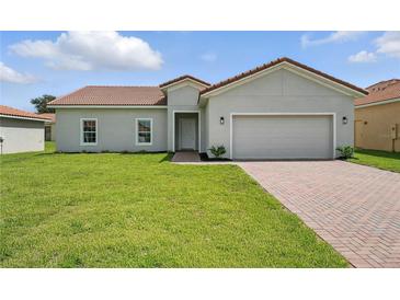Charming single-story home featuring a well-manicured lawn and a classic tile roof at 436 Caraway Dr, Kissimmee, FL 34759