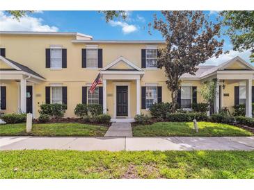 Charming two-story townhome featuring a welcoming entrance with black shutters and a well-manicured lawn at 5235 Keenes Pheasant Dr, Windermere, FL 34786