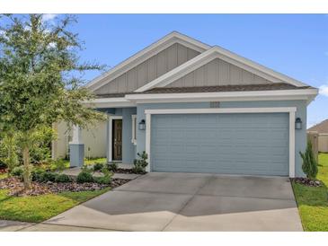 Charming single Gathering home featuring light blue exterior paint and an attached two car garage at 555 Jett Ln, Davenport, FL 33837