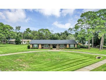 Beautiful ranch style home with a circular driveway and well-manicured lawn and landscaping at 1071 Deer Run Dr, Winter Springs, FL 32708