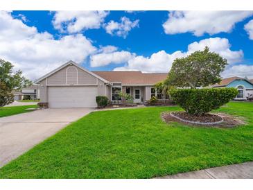 Charming single-story home featuring a well-maintained lawn and a two-car garage at 2223 Fairmont Cir, Orlando, FL 32837