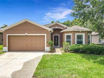 Charming single-story home featuring a two-car garage, well-maintained lawn, and inviting curb appeal at 5431 Lochdale Dr, Orlando, FL 32818