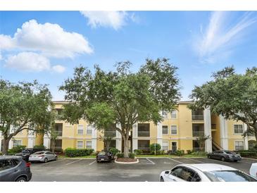 View of the condo building with parking lot and landscaping, under a sunny sky with scattered clouds at 1125 Lake Shadow Cir # 5109, Maitland, FL 32751