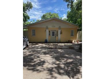 Modest yellow single-story home with symmetrical facade and a front parking area at 1218 37Th St, Orlando, FL 32805