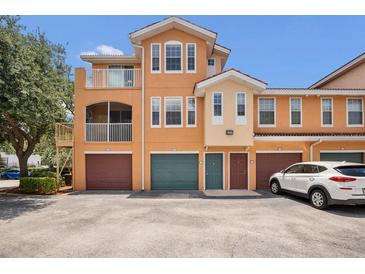 Three-story townhome with individual garages and inviting neutral color palette on a sunny day at 12414 Baleria Cv # 104, Orlando, FL 32837