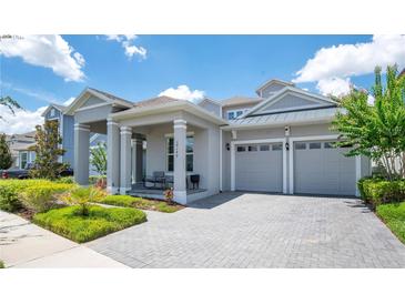 Charming home with a two-car garage, covered porch with ample seating, and paver driveway at 14189 Larkspur Lake Dr, Winter Garden, FL 34787