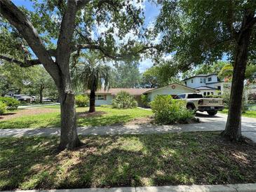 Traditional single-story home with a well-maintained lawn, mature trees, and a large driveway at 1730 Oneco Ave, Winter Park, FL 32789