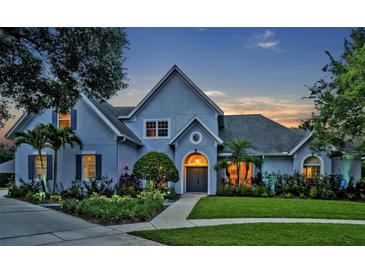 Charming two-story home with beautifully landscaped yard and inviting entrance at dusk at 2523 Madron Ct, Orlando, FL 32806