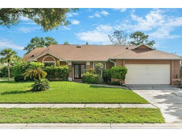 Charming single-story home with well-maintained landscaping, lush lawn and a two car garage at 2809 Gulf Winds Ct, Oviedo, FL 32765