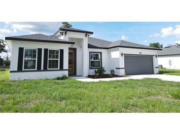 Charming single-story home features a two-car garage, crisp white stucco, and black accents at 3159 Sw 127Th Lane Rd, Ocala, FL 34473