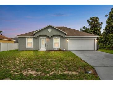 Charming single-story home with a well-maintained lawn and attached two-car garage at 446 Arkansas Ct, Poinciana, FL 34759