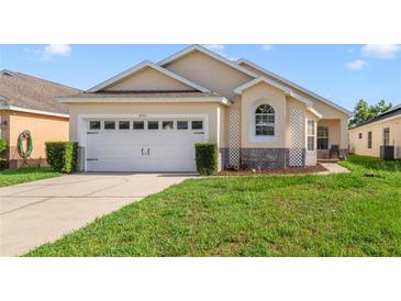 Charming single-story home with a well-manicured lawn and attached two-car garage at 4533 Oakbrook Ct, Kissimmee, FL 34746