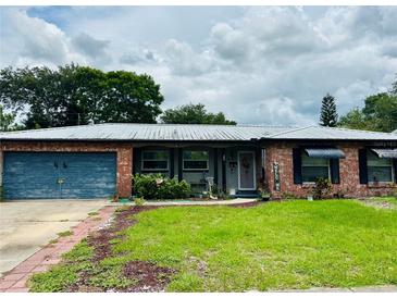 Charming single-story home with a well-maintained lawn, brick facade and attached garage at 46 Carriage Hill Cir, Casselberry, FL 32707