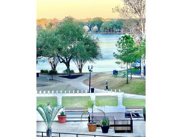 Scenic lake view featuring walking path, lush trees, and serene water at 151 E Washington St # 508, Orlando, FL 32801