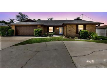 Charming single-story brick home featuring a well-manicured front yard and a two-car garage at 1736 Saxon Blvd, Deltona, FL 32725