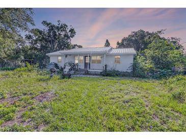 Charming single-story home featuring a metal roof and set on a spacious lot surrounded by mature trees at 2915 Dean Ridge Rd, Orlando, FL 32825