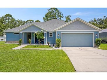 Charming, single-story home with a manicured lawn, attached garage, and a welcoming front porch at 5531 Marys Villa Rd, Groveland, FL 34736