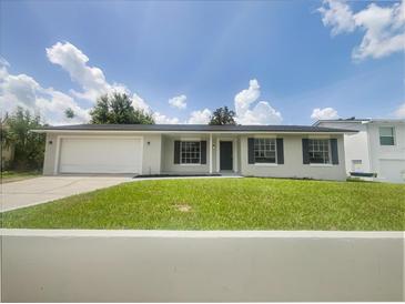Charming single-story home with a well-manicured lawn, attached garage and a cozy front entrance at 7040 Hennepin Blvd, Orlando, FL 32818
