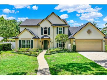 Charming two-story home featuring a well-manicured lawn, lush landscaping, and an inviting walkway to the front door at 991 Hawthorne Cove Ct, Ocoee, FL 34761