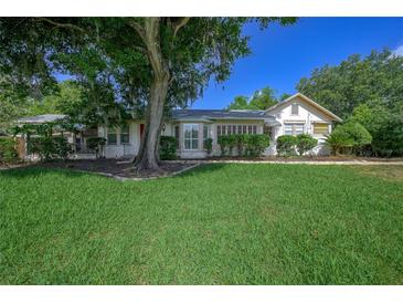 Charming one-story home with lush green lawn, mature tree, and well-maintained landscaping at 1621 Sunnyside Dr, Maitland, FL 32751