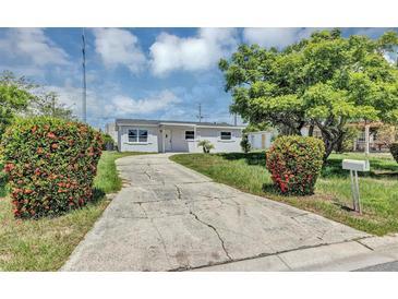 Charming single-story home featuring a well-maintained lawn and a cracked concrete driveway at 603 Carver Dr, Lake Wales, FL 33853