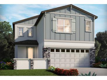 Charming two-story home featuring light-blue siding, stone accents, a two-car garage and lush landscaping at 651 Pennywort St, Lake Alfred, FL 33850