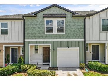 Inviting two-story townhome with a one-car garage and charming, well-maintained landscaping at 827 Grandin St, Davenport, FL 33837