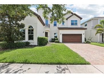 Charming two-story stucco home featuring a tile roof, well-manicured lawn and attached two-car garage at 9207 Busaco Park Way, Winter Garden, FL 34787