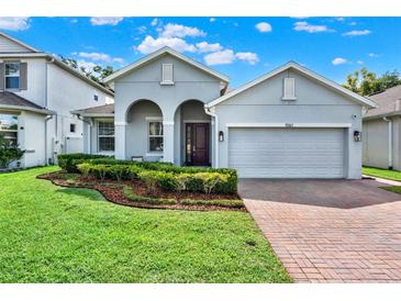 Charming single-Gathering home with a well-manicured lawn, brick driveway, and inviting curb appeal at 1061 Castlevecchio Loop, Orlando, FL 32825